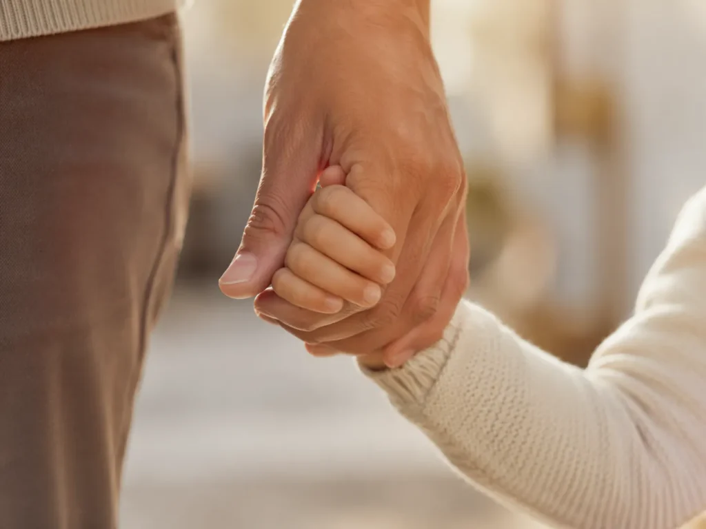 Mano de un adulto y un niño para custodia de hijos y régimen de visitas en Vilagarcía de Arousa